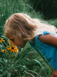 Valokuva: Tyttö haistaa kukkia